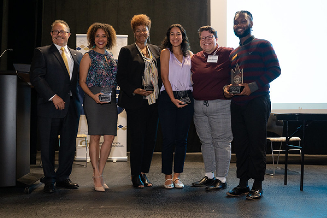 the 2022 Diversity Champion Award Winners pose on stage with Dr. Ervin