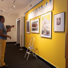 Jerushia Graham (foreground), museum coordinator, and Virginia Howell, museum director, install A Community of Artists: African American Works on Paper From the Cochran Collection. Photo by Joya Chapman.